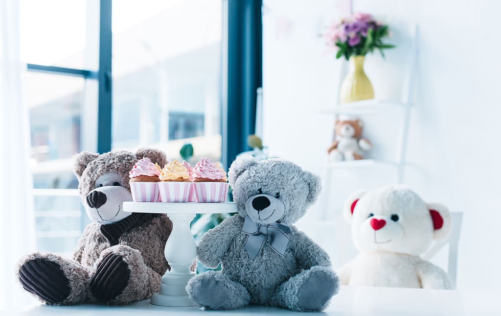 Cute teddy bears with cupcakes in a classroom