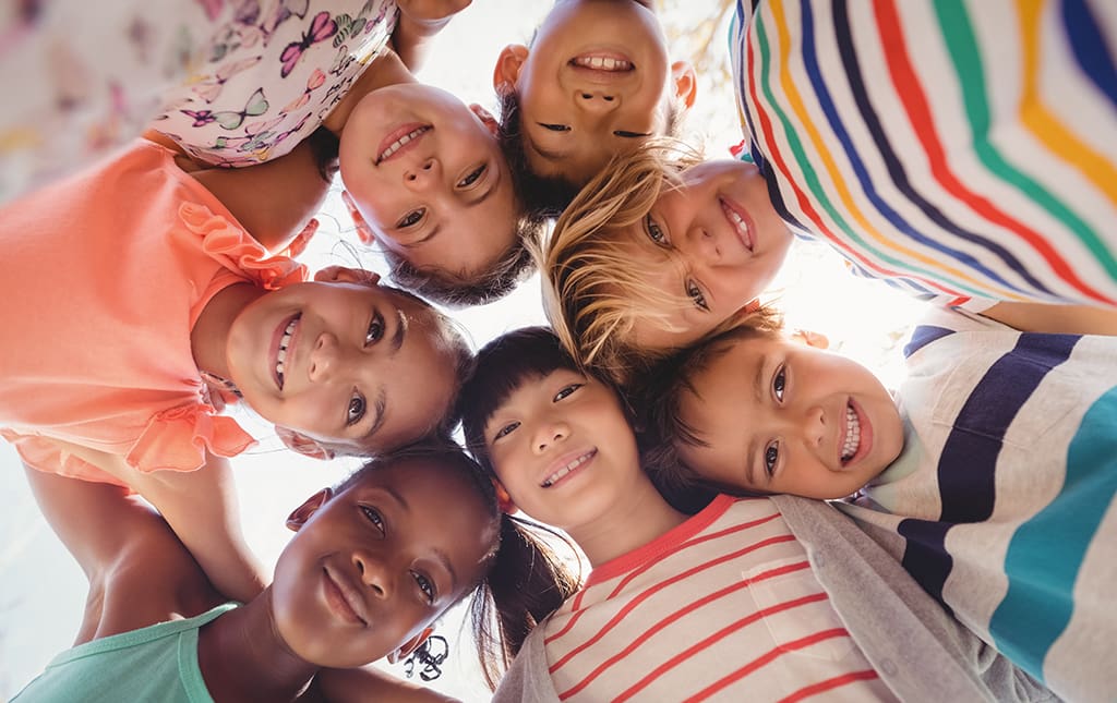 Kids huddling together during a kindness campaign in school.