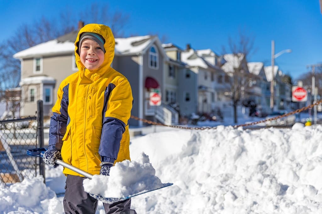 Student shoveling snow as part of chores auction December school fundraiser
