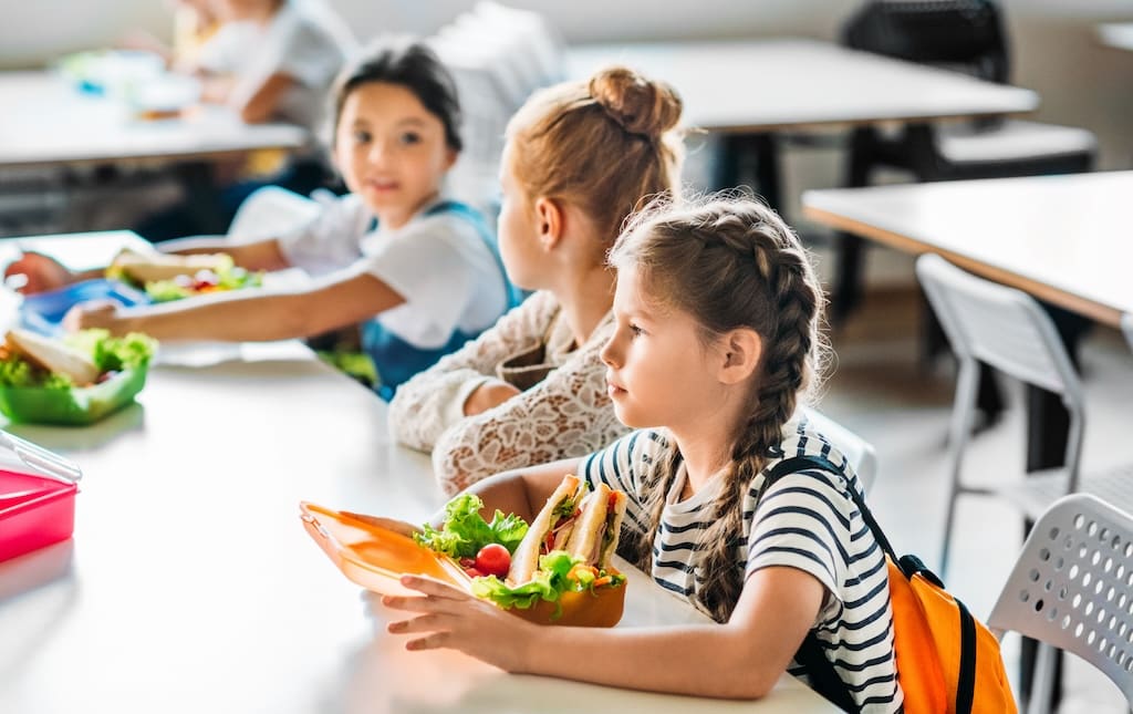 School children eating lunches during a lunch and learn presentation