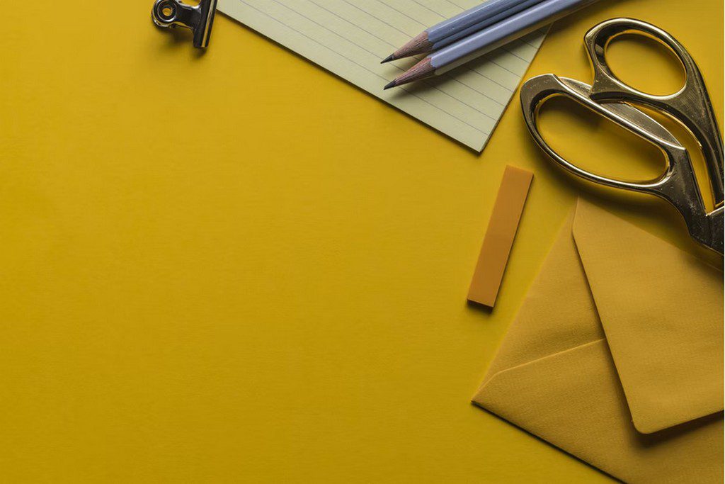 A pair of scissors with yellow envelopes