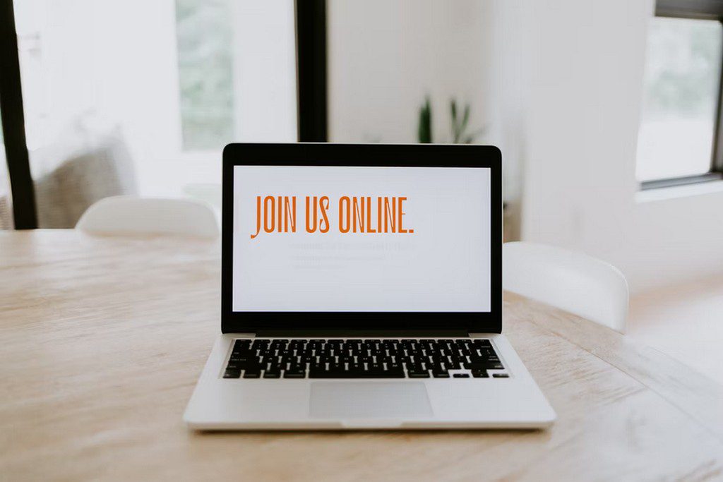 A laptop with the words "Join Us Online" on the screen