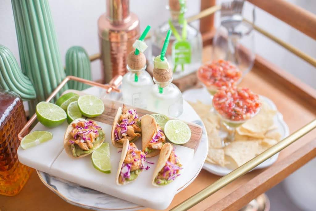 A plate with tacos and limes