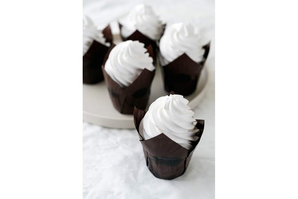 Cupcakes with white frosting in black sleeves
