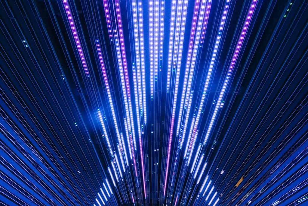 A ceiling with purple and blue LED lights that are linear