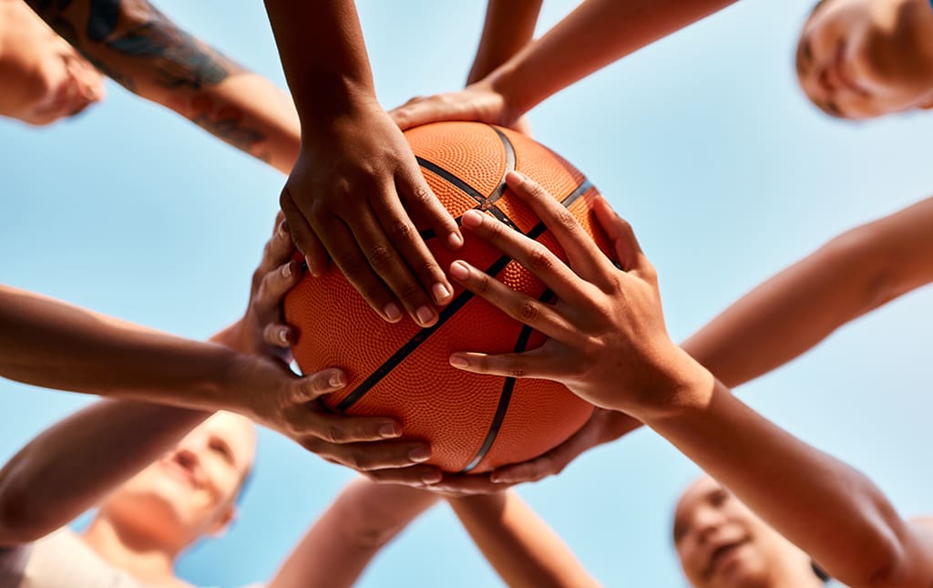 Kids holding a basketball at the start of a school fundraiser tournament during March Madness.