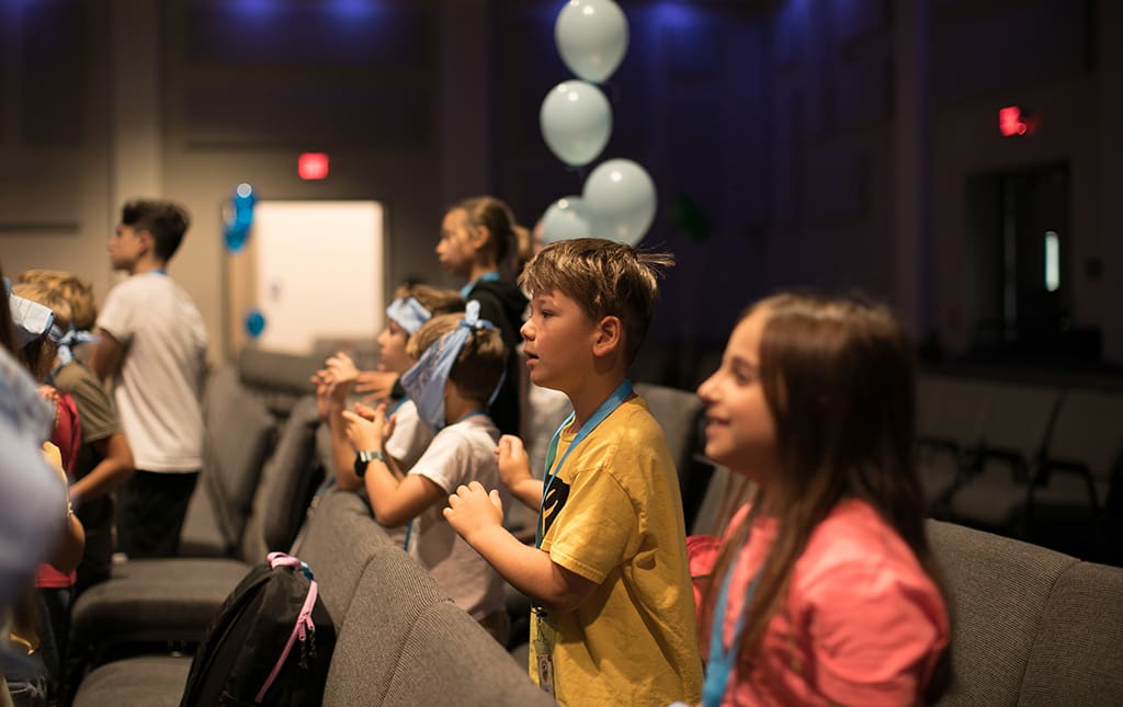 Kids participating in a family game show night in the school auditorium.
