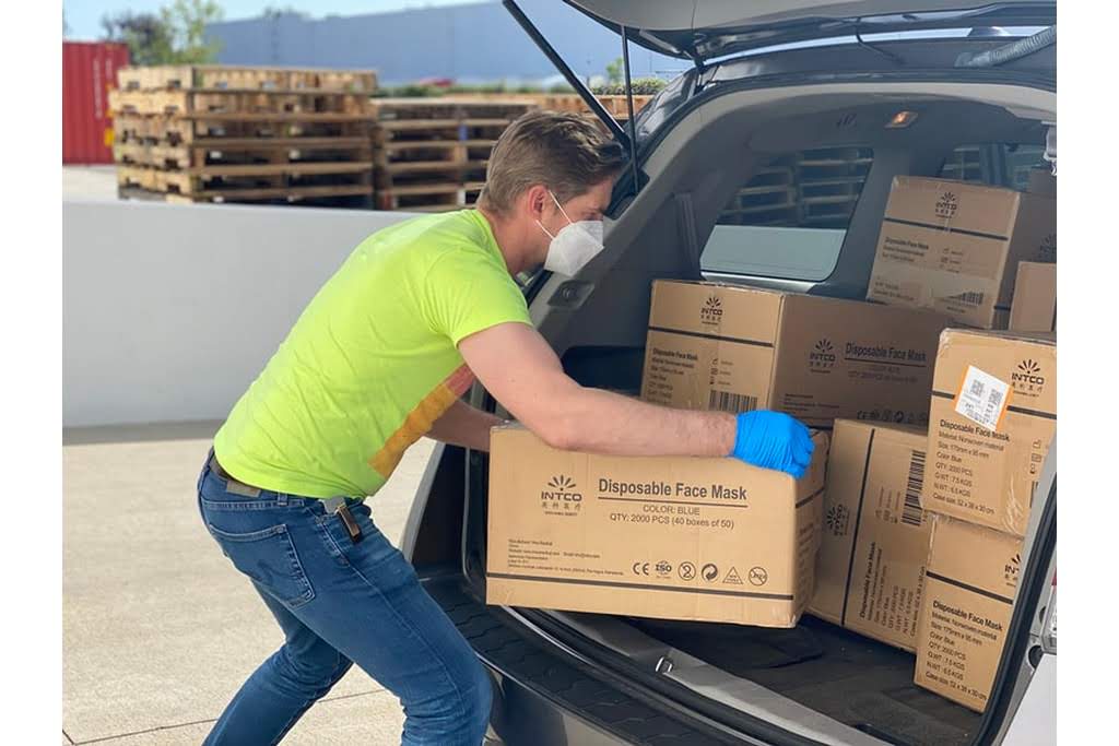 A White man loads boxes into the trunk of a car man loading suv with boxes