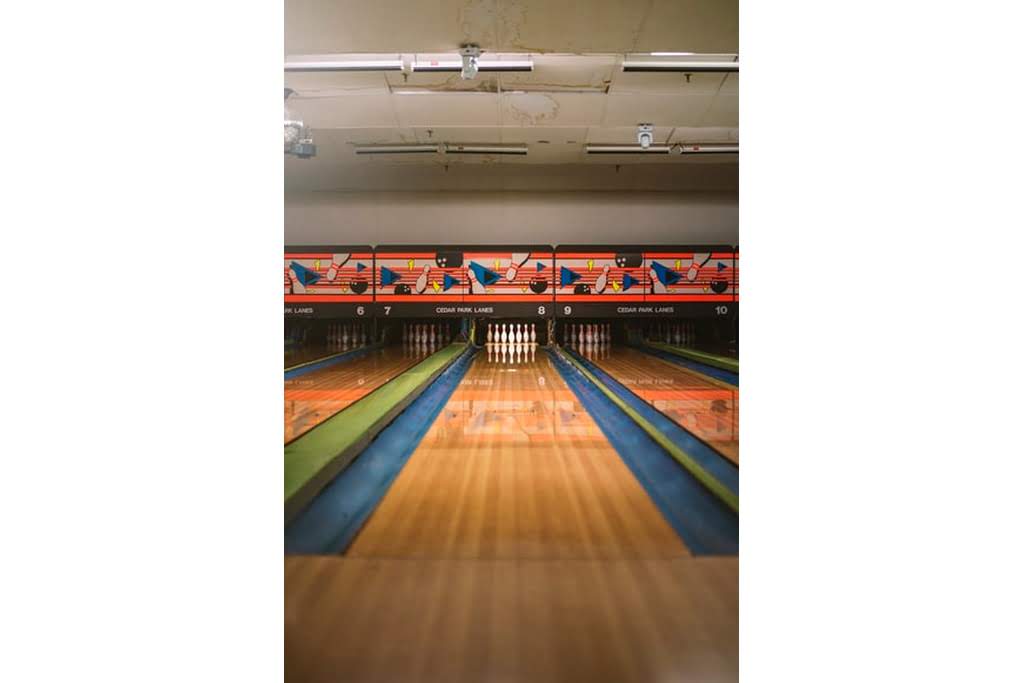A dimly lit bowling alley lane with bowling pins bowling aleey