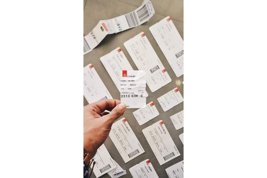 A hand holding a plane ticket plane tickets