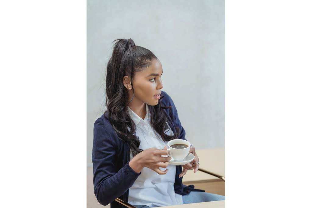 A Black girl drinking hot chocolate from a cup woman drinking coffee