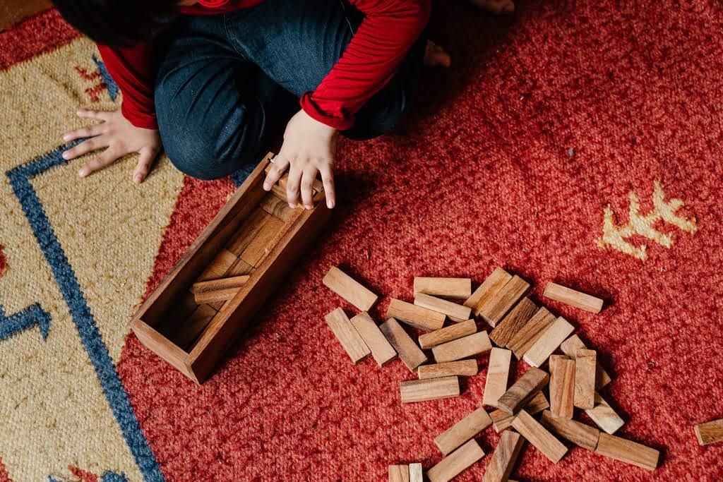 A set of hands playing with a puzzle rummy game