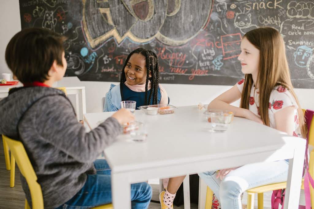Three children sitting around a table kids at a teble