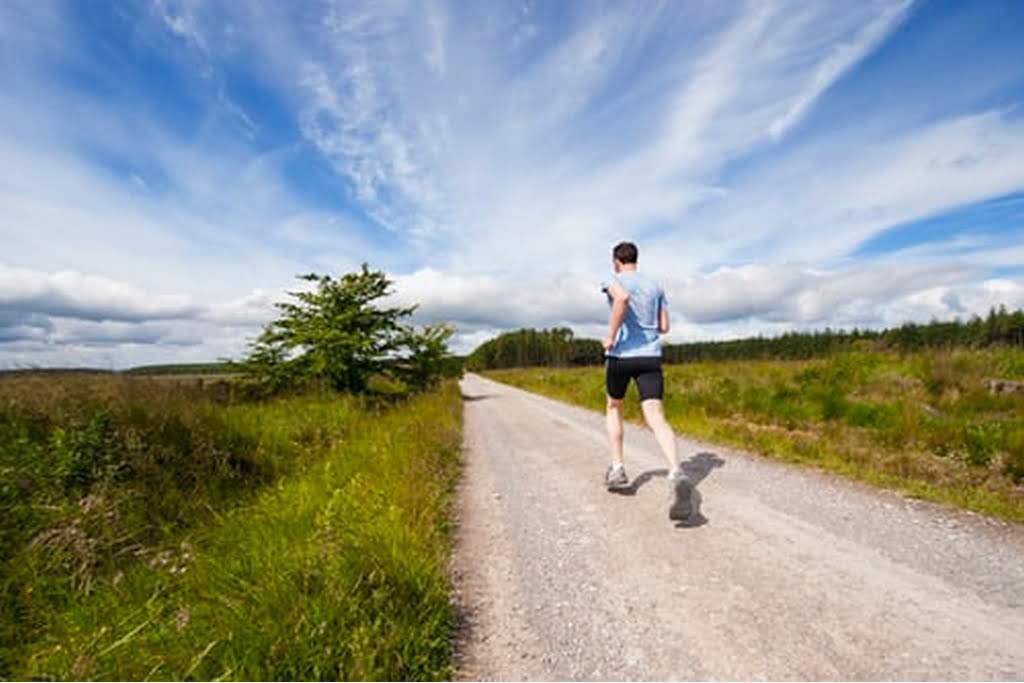 man jogging on dirt road