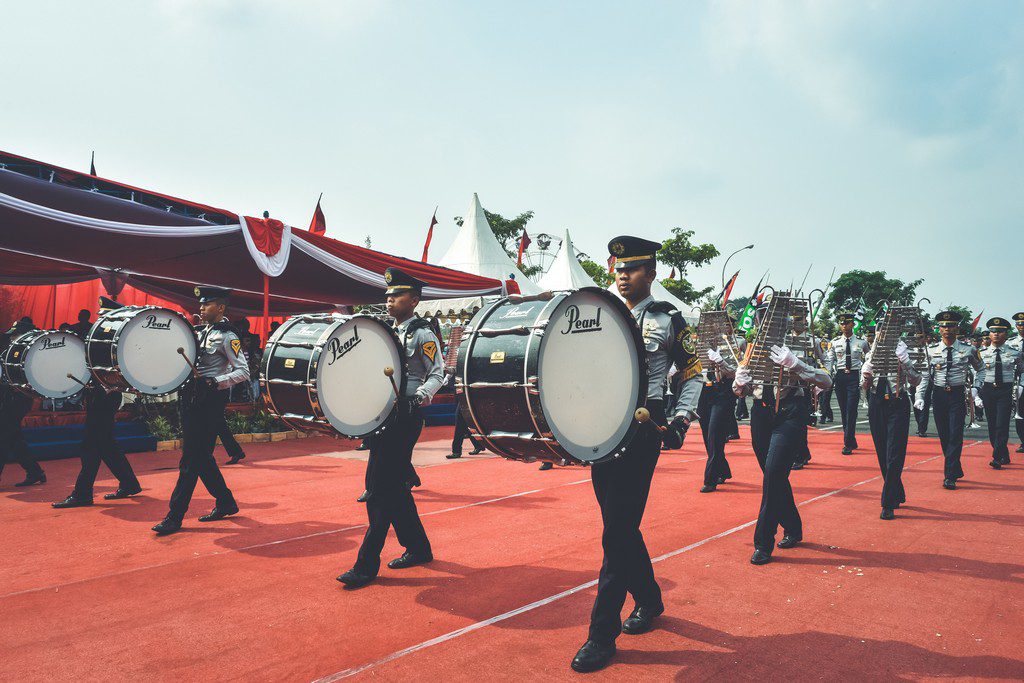 A black marching band walks forward marching band