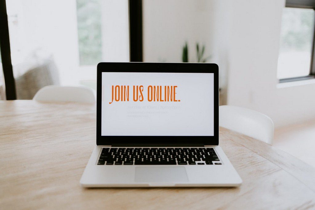 A computer with the words "Join Us Online" on the screen laptop with join us online on the screen