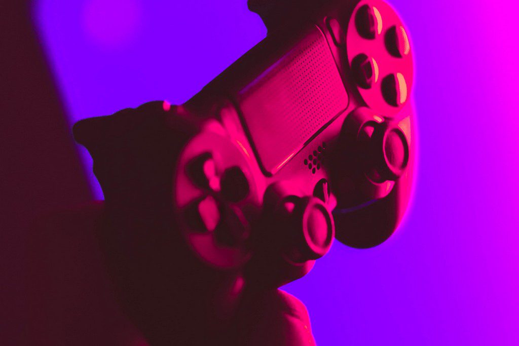 A game controller with purple and pink lighting ps4 controller