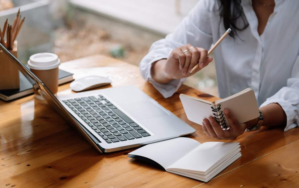 woman taking notes on her laptop