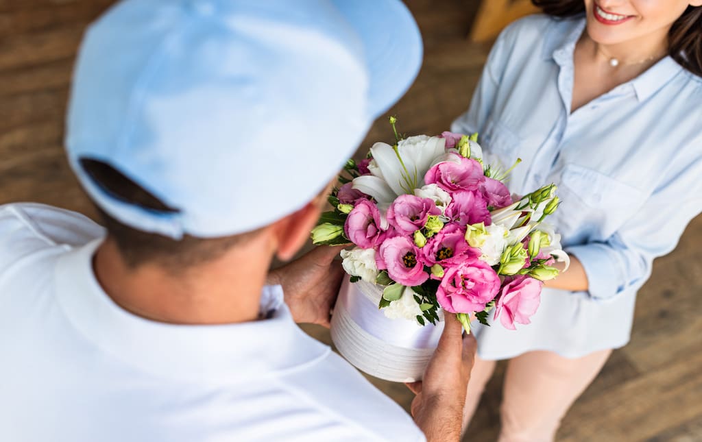 Man Delivery a Small Bouquet of Pink Flowers to a Woman
