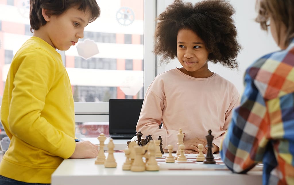 School age students playing chess