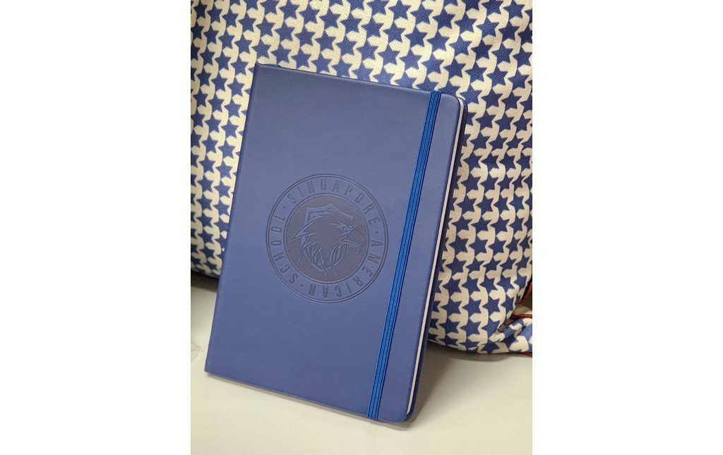 School logo embossed on notebook cover