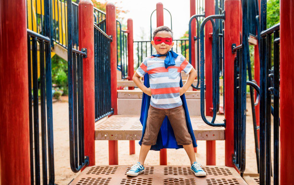 kid dressed as a superhero on the playground