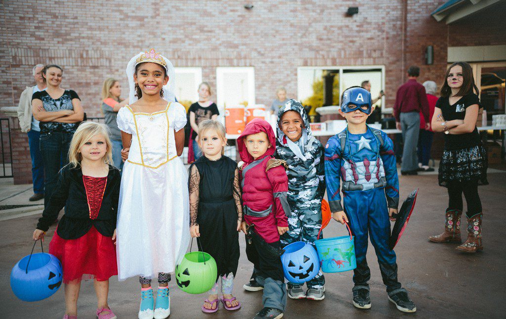 Students standing in classroom wearing costumes for dress up day fundraiser