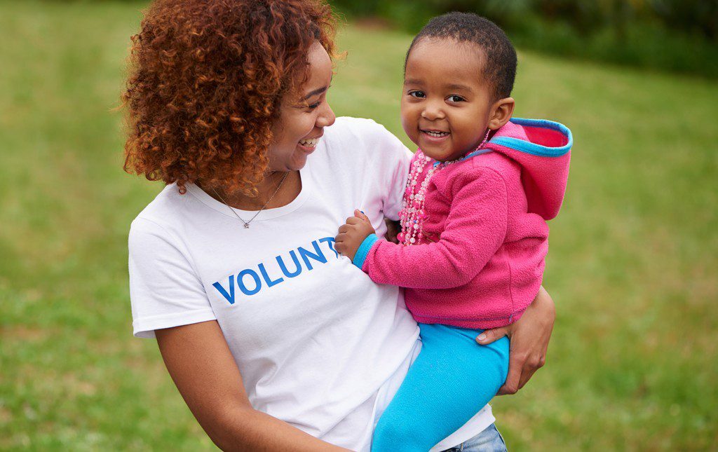 Mom volunteering while holding daughter at a fundraiser