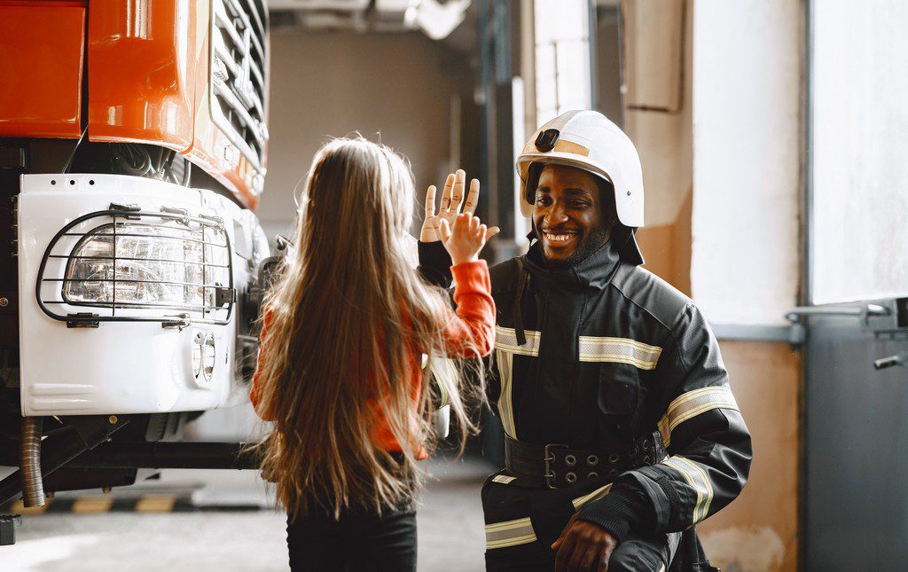 Fireman giving a young girl a high five at the fire station