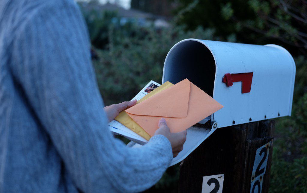 Woman grabbing mail from a mail writing campaign