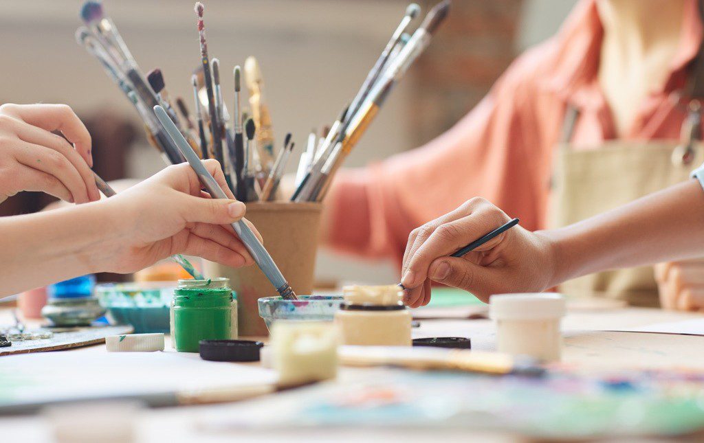 Students using paints at arts and crafts end of school year party