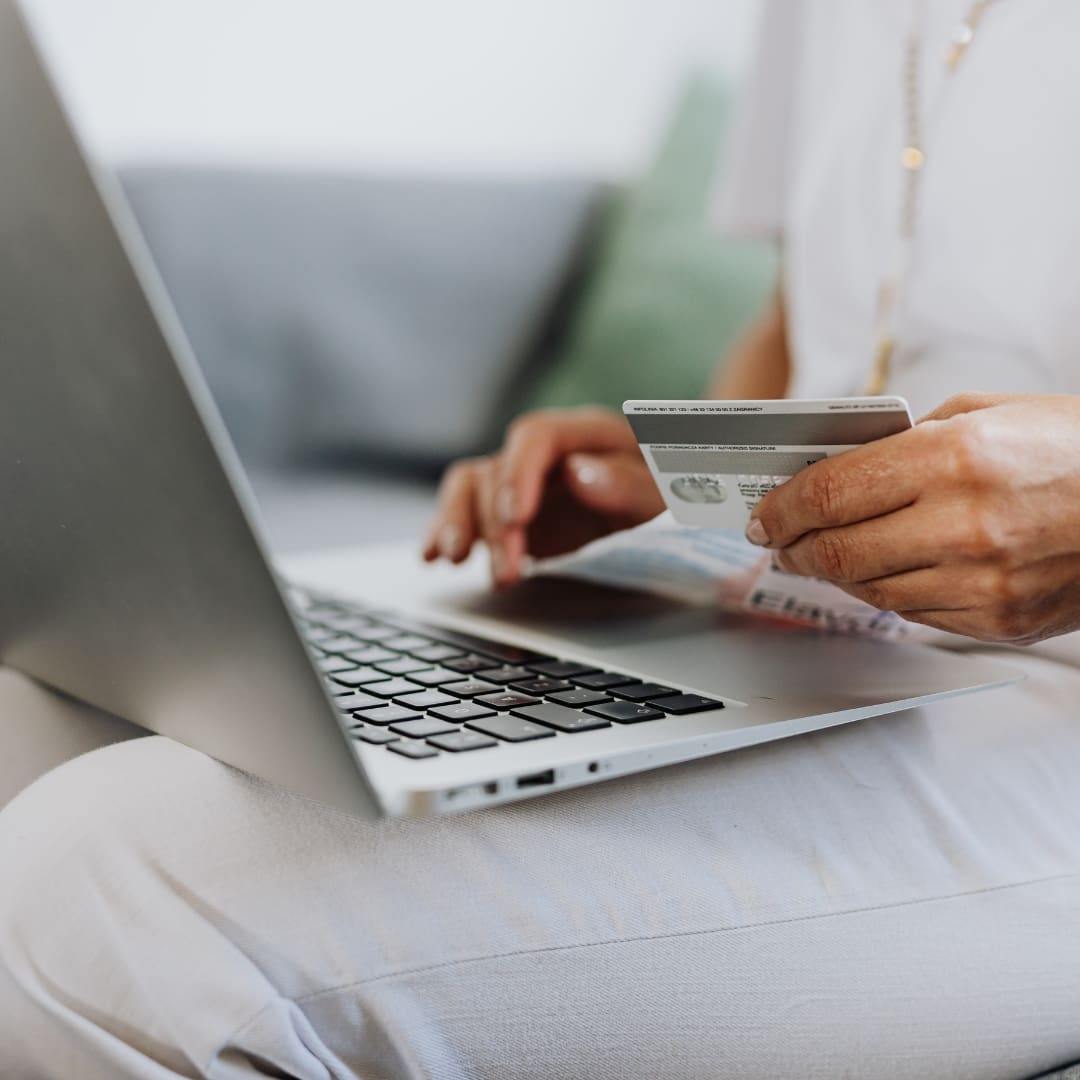 laptop on lap with credit card to shop online
