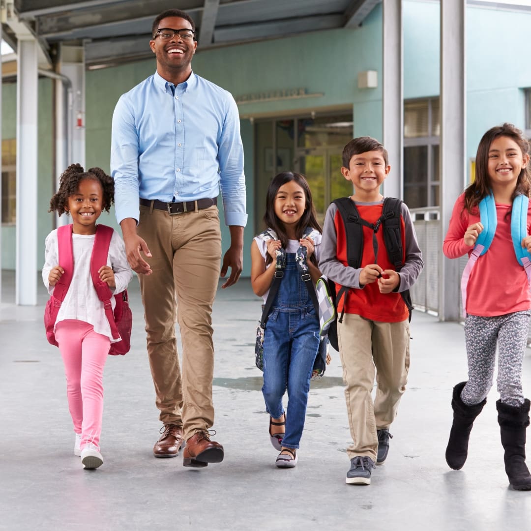 futurefund-recess-volunteer man walking with kids to recess<br />