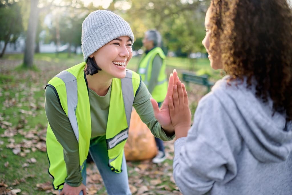 Parent volunteer giving hi-five to student in after-school program