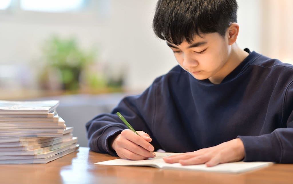 middle school age boy writing letters