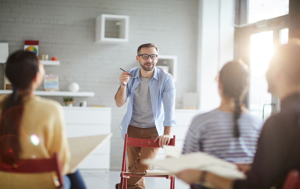 Young Male Art Teacher Standing in Front of Audience