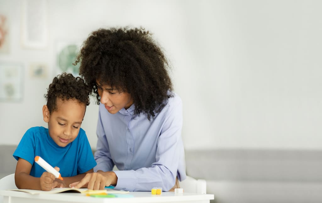Parent Helping Young Child to Write a Letter