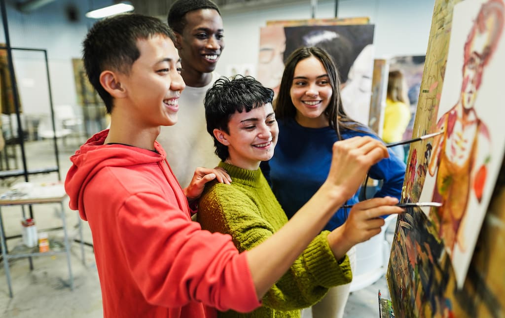 Group of High School Aged Students Painting In Art Room