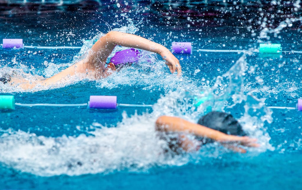Young Male Swimmers Racing