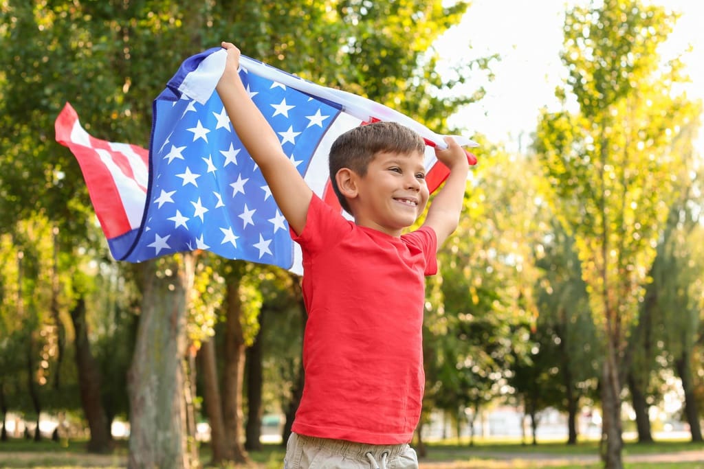 Elementary student with stars and stripes flag for 4th of July school fundraiser