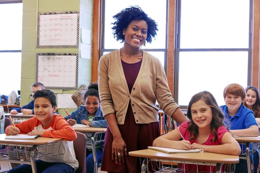 Smiling teacher in elementary school classroom during teacher appreciation week 2024