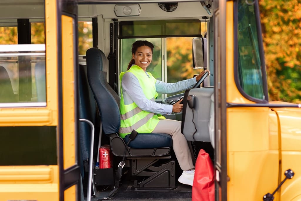 Smiling school bus driver in bus