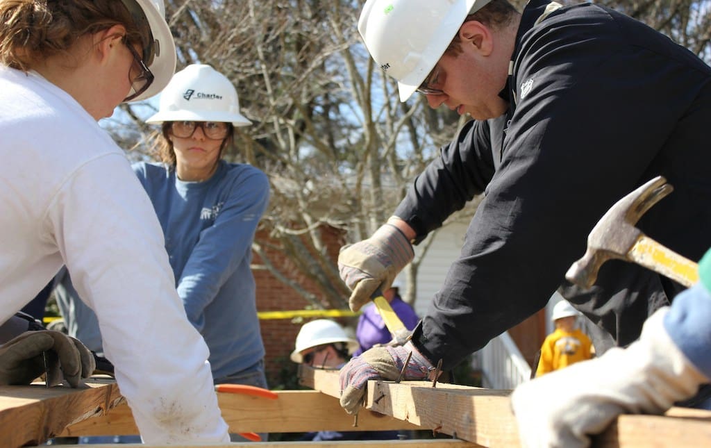 Volunteers performing community service by building a house