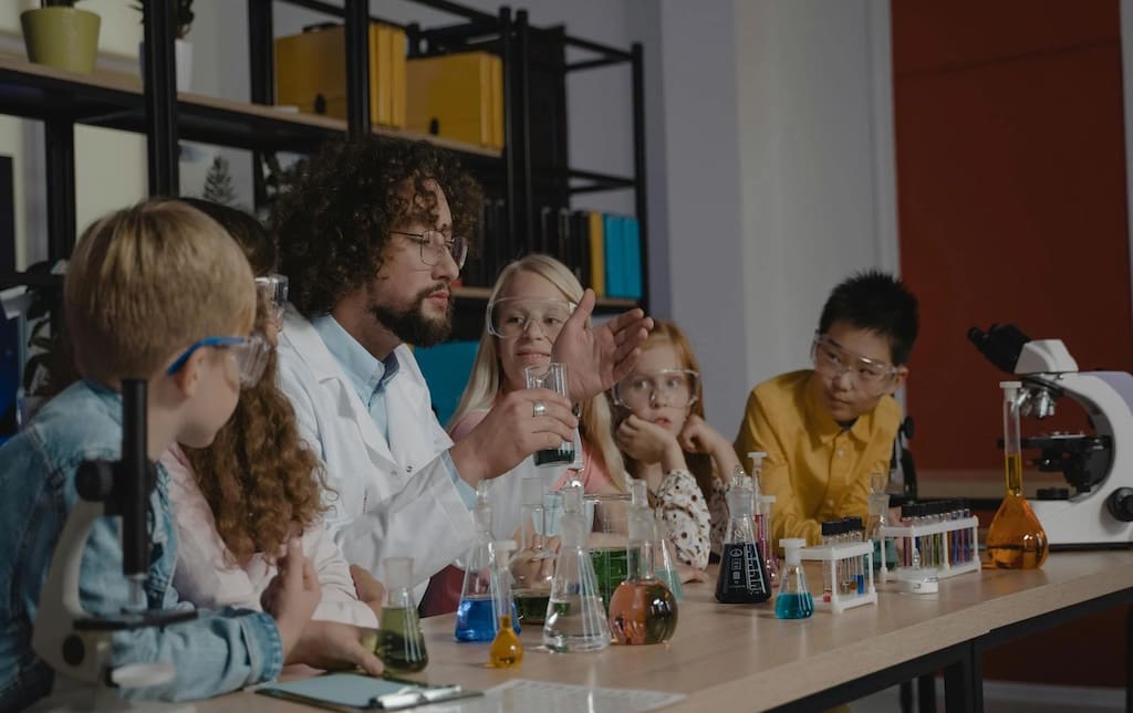 Male teacher doing science experiments with students